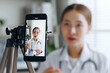 © Nattakorn - Asian woman doctor making online live streaming broadcast talking over camera recording in hospital, medical and healthcare blogger, vlogger concept