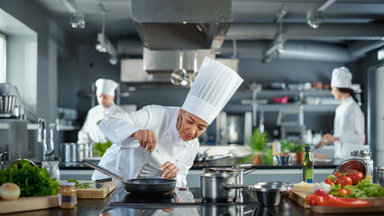 Wall Mural - Restaurant Kitchen: Black Female Chef Cooking Delicious and Traditional Authentic Food, Uses Oil on Pan Getting Ready to Fry Organic Free Range Meat Patty. Preparing gourmet Dishes. Wide Shot