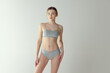 © master1305 - Portrait of yound tender girl with toned fit body posing in underwear isolated over grey studio background