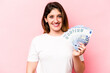 © Asier - Young caucasian woman holding banknotes isolated on pink background happy, smiling and cheerful.
