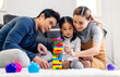 © Art_Photo - Portrait of enjoy happy love asian family father and mother with little asian girl smiling activity learn and skill brain training play with toy build wooden blocks board education game at home