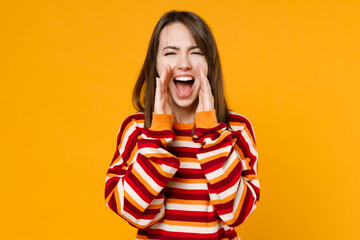 Young happy promoter fun woman 20s in red striped sweatshirt scream hot news about sales discount with hands near mouth isolated on plain yellow background studio portrait. People lifestyle concept.