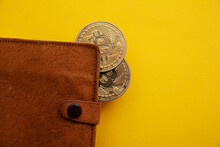 Brown leather crypto curreency wallet with a bitcoin gold coin. Digital finance concept