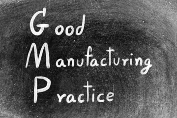 Poster - White hand writing in word GMP good manufacturing practice on black board background