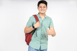 Portrait of happy indian teenager college or school boy with backpack do thumbs up, isolated on white background. Smiling young asian male kid looking at camera.