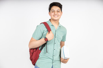 Portrait of happy indian teenager college or school boy with backpack holding books, isolated on white background. Smiling young asian male kid looking at camera.