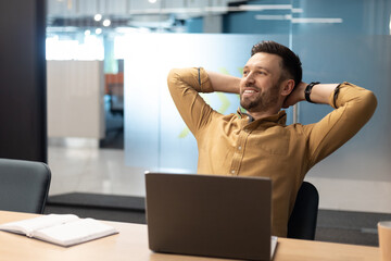 Poster - Cheerful Business Man Relaxing Sitting Near Laptop In Modern Office