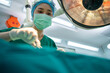 © Prot - Asian Professional surgeons team performing surgery in the operating room, surgeon, Assistants, and Nurses Performing Surgery on a Patient, health care cancer and disease treatment concept