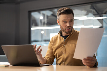 Poster - Shocked Businessman Reading Papers Having Problem Using Laptop In Office