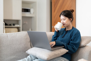 Wall Mural - Image of young asian cheery happy positive cute beautiful business woman sit indoors in office using laptop computer