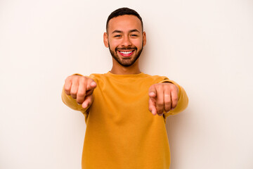 Wall Mural - Young hispanic man isolated on white background cheerful smiles pointing to front.