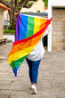 © DoloresGiraldez - young  woman hanging out in the village waving LGBT with pride flag.