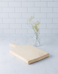 A cutting board is on the worktop in the kitchen. Vertical picture.
