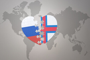 puzzle heart with the national flag of russia and faroe islands on a world map background. Concept.