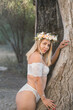 © Seim - Latina fairy nymph in white with flowers in hair poses inside a giant old tree