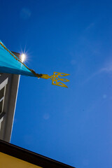 the flag of Ukraine and the golden trident coat of arms in the blue summer sky, a symbol of the state