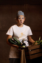 Amazed Mime Chef Holding Basket With Veggies And Kitchenware In Studio