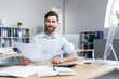 © Liubomir - Young male businessman. Accountant, economist, financier. Works with documents, papers, reports, schedules. Sitting at his desk at the computer