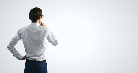 Poster - Thinking concept with pensive businessman in white shirt standing on abstract white wall backdrop, with empty place for you text, mock up
