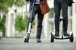 © DragonImages - Cropped image of university lecturers riding on electric scooters to campus