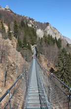 Long Suspension Bridge Made Of Sturdy Steel Ropes Connecting The Two Ends Of A Landslide In The Mountains