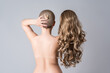 © staras - Topless woman with curly blonde wig on gray background, naked female back