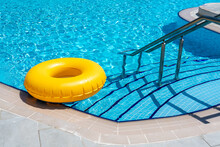 Yellow Ring Floating In Refreshing Blue Swimming Pool