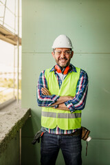 Wall Mural - Portrait of men in 40s, construction worker. He is standing in construction and posing for camera.