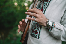 Hands Of Young Man Playing On Woodwind Wooden Flute - Ukrainian Sopilka Outdoors. Folk Music Concept. Musical Instrument. Musician In Traditional Embroidered Shirt - Vyshyvanka.