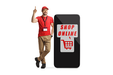 Sticker - Male shop assistant standing next to a smartphone with text shop online and pointing up