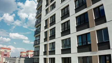 Wall Mural - Flying along the high rise newly built residential building on a summer day. Stock footage. Concept of urbanization.