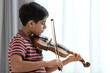 © chomplearn_2001 - Indian boy practicing violin at home playing the violin by the window at home