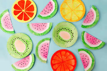 Fruit made of paper - watermelon, kiwi, lemon, grapefruit. Blue background. Tropics creative concept, kindergarten, daycare handmade papercraft, summer season, sweet food. Flat lay.