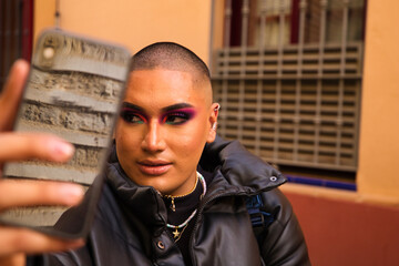 Non-binary and young person from South America is on holiday in Europe, the person is make up and wearing black clothes. He is visiting the city and takes pictures with his mobile phone. Travel