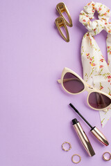 Wall Mural - Make up concept. Top view vertical photo of white scarf scrunchy mascara sunglasses gold rings and two barrettes on isolated pastel violet background