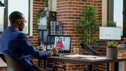 Wall Mural - African american worker meeting with businesswoman on online video call, using teleconference chat to have remote conversation. Talking on virtual internet webcam videoconference.