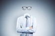 Headless invisible businessman with folded arms and abstract glasses standing on gray wall background. Business and secret concept.
