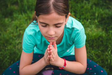 A child prays to god in the park. Selective focus.