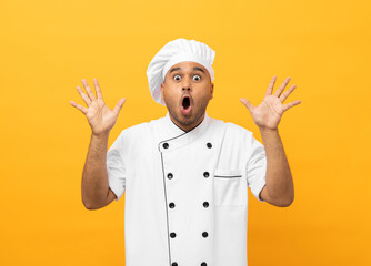 Wall Mural - Wow excited face Young handsome asian man chef in uniform with hat standing posting looking camera on isolated. Cooking indian man Occupation chef People in kitchen restaurant and hotel.