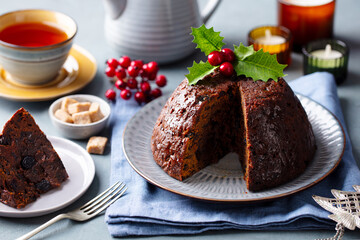 Wall Mural - Christmas pudding, fruit cake with cup of tea. Traditional festive dessert. Grey background. Close up.