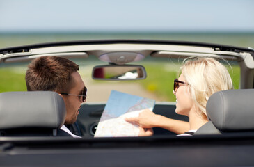 Sticker - road trip, travel and tourism concept - happy couple with map driving in convertible car with map