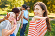 © Robert Kneschke - Happy young woman meets friends in the park in summer