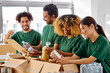 © Syda Productions - charity, donation and volunteering concept - international group of happy smiling volunteers packing food in boxes according to list on clipboard at distribution or refugee assistance center
