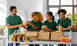 © Syda Productions - charity, donation and volunteering concept - international group of happy smiling volunteers packing food in boxes at distribution or refugee assistance center