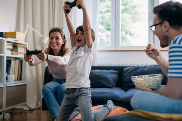 Wall Mural - happy family playing video games at home