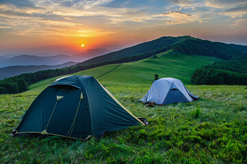tent stand on a mountain range in the carpathians at sunset