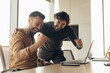 © Prostock-studio - Business success. Coworkers celebrating achievement, making profitable deal, gesturing YES in front of laptop at office