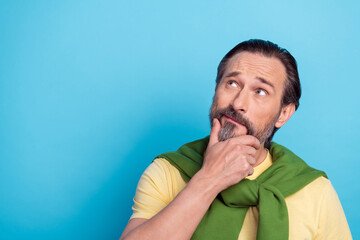 Poster - Portrait of minded person arm chin look interested empty space isolated on blue color background