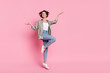 Full length photo of young cheerful lady have fun jump ads advantage recommend isolated over pink color background