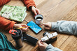 © Przemek Klos - Family planning vacation trip. Girl searching travel destination and routes using navigation map on mobile phone. Charging smartphone with power bank. Using technology while travelling